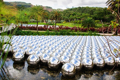 Vista del sinuoso camino de piedra en la Galería Yayoi Kusama en Inhotim, rodeado de vegetación exuberante