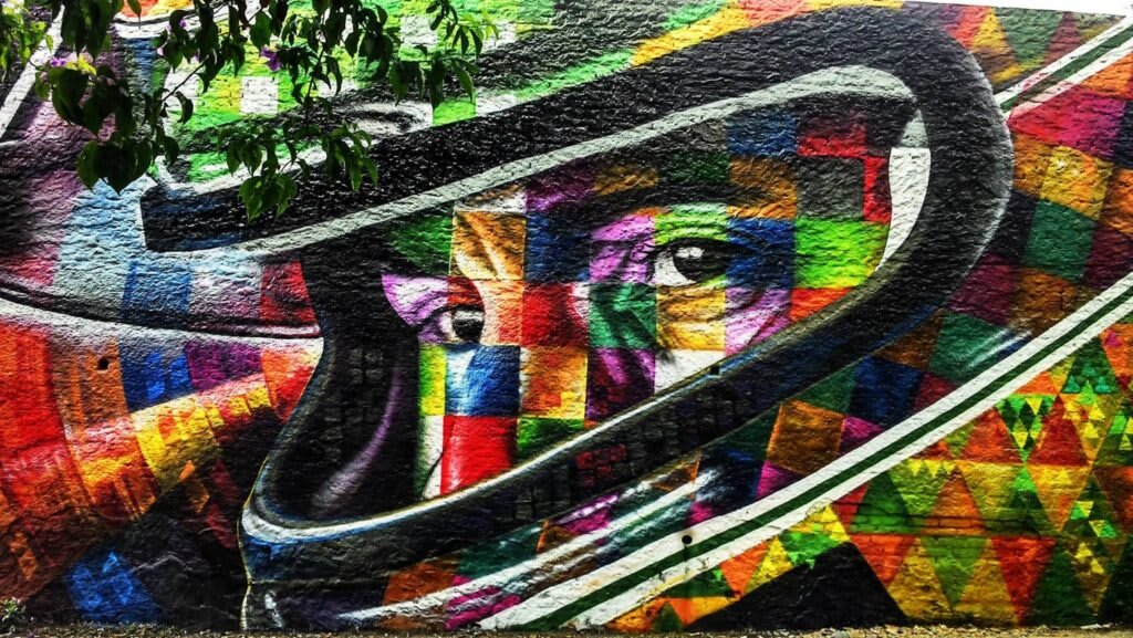 Biografía de Eduardo Kobra - La leyenda de Brasil: Realizada en 2015, la pintura se encuentra en el lateral de un edificio en la Rua Consolação, cerca de la Avenida Paulista en la zona central de São Paulo. Mide 41 metros de altura. En 2016, el muralista pintó al mito Ayrton en la zona de los Arcos de Lapa en Río de Janeiro y en 2019, con motivo de los 25 años del fallecimiento del gran ídolo brasileño, Kobra recibió un encargo para retratar a Senna en el autódromo de Imola, donde el piloto brasileño falleció.